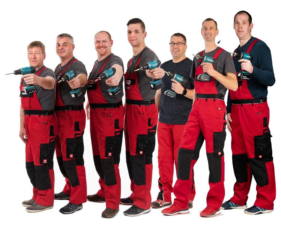 Das siebenköpfige Montage-Team von Möbel Müller in roter Arbeitskleidung mit Akkuschraubern